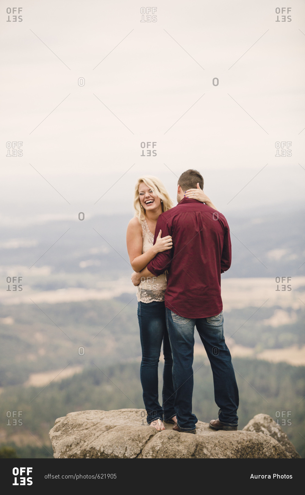 Portrait of engaged couple smiling hugging and standing on hill, Eugene, Oregon, USA