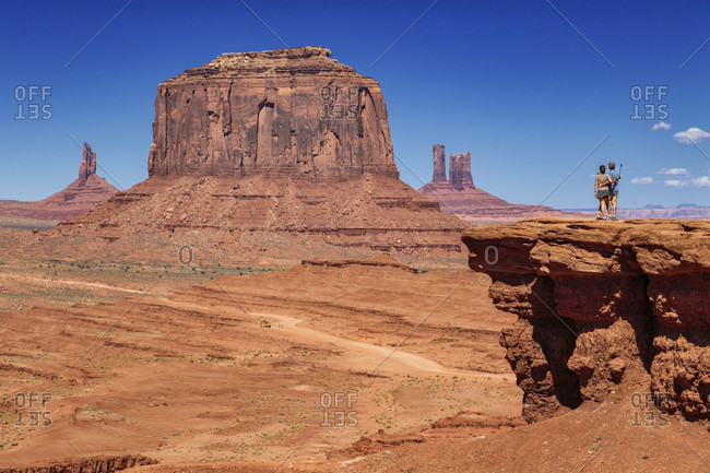 Two people standing on rock at Monument Valley, Arizona, USA