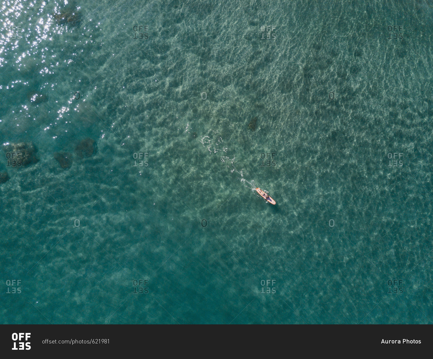 Aerial view of young woman surfing in crystal clear water, Tenerife, Canary Islands, Spain