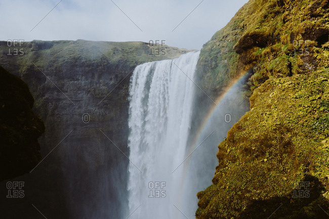 Rainbow and a waterfall on a green mountainside