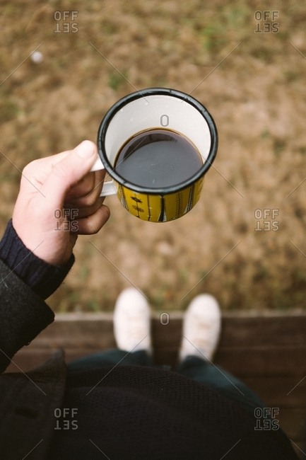 Man Looking Down At His Cup Of Coffee Outdoors Stock Photo Offset