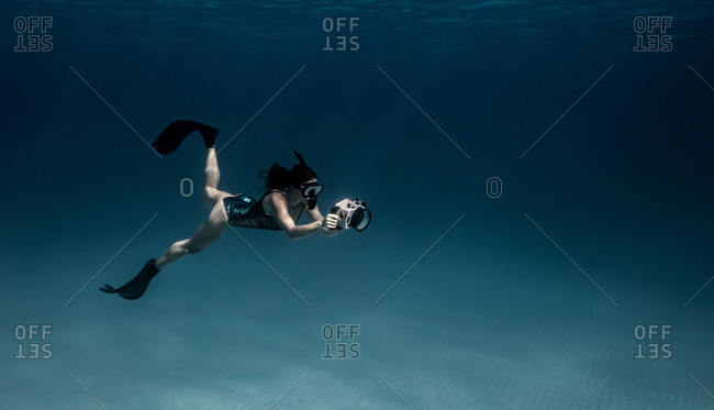 Underwater view of female free diver with underwater camera, Bimini, Bahamas