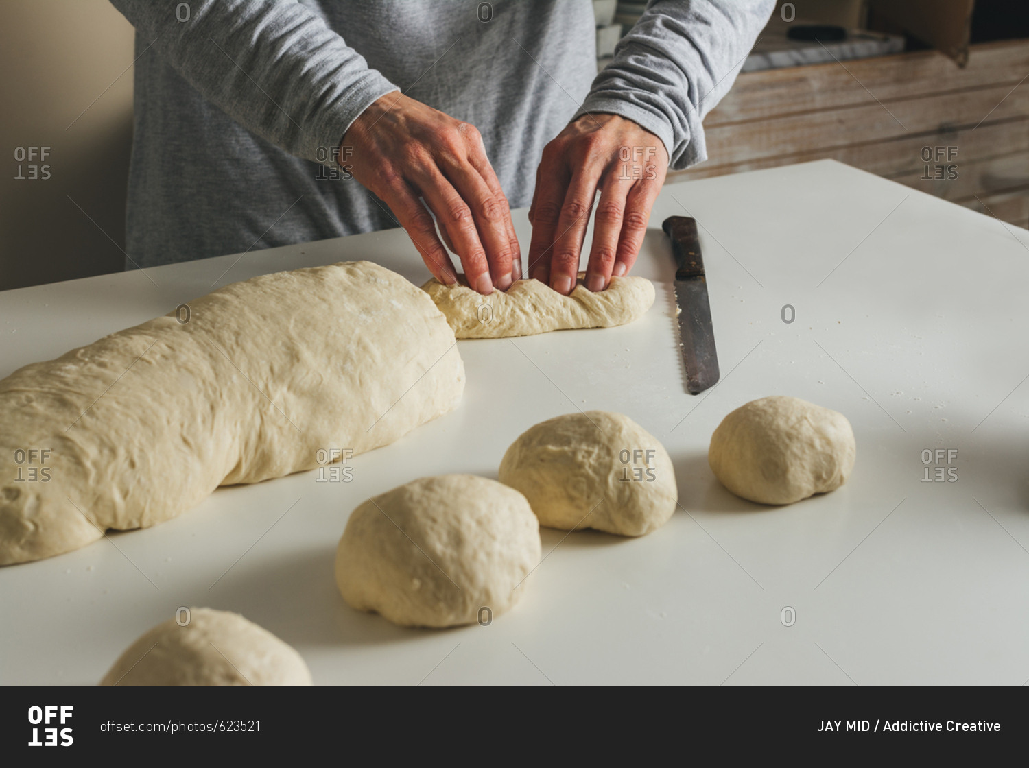 woman massing bread: folding the dough into thirds, and sealing with the fingers