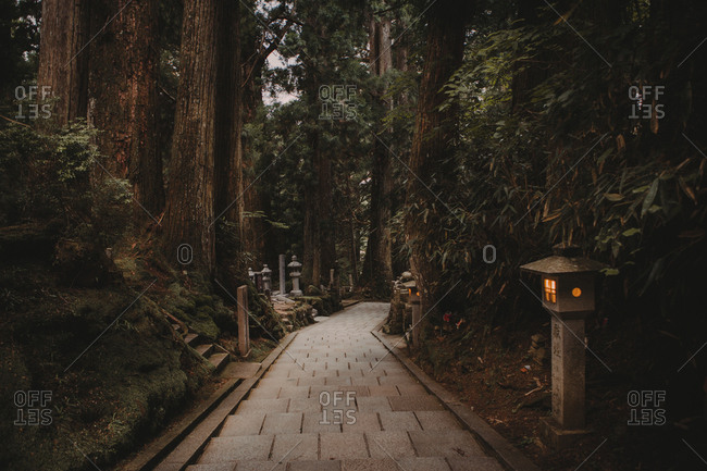 Koyasan, Japan - September 10, 2017: View of walkway running way among trees on territory of ancient oriental sacred temple
