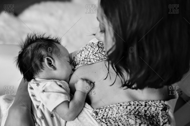 Mother holding breastfeeding baby - Offset