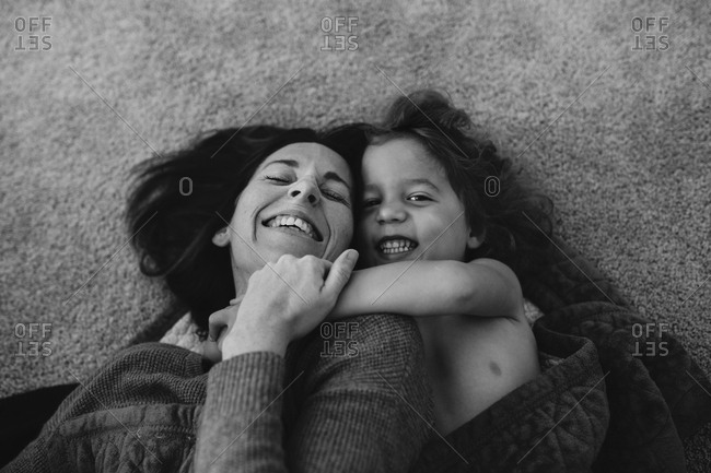 Woman and boy laying on carpet