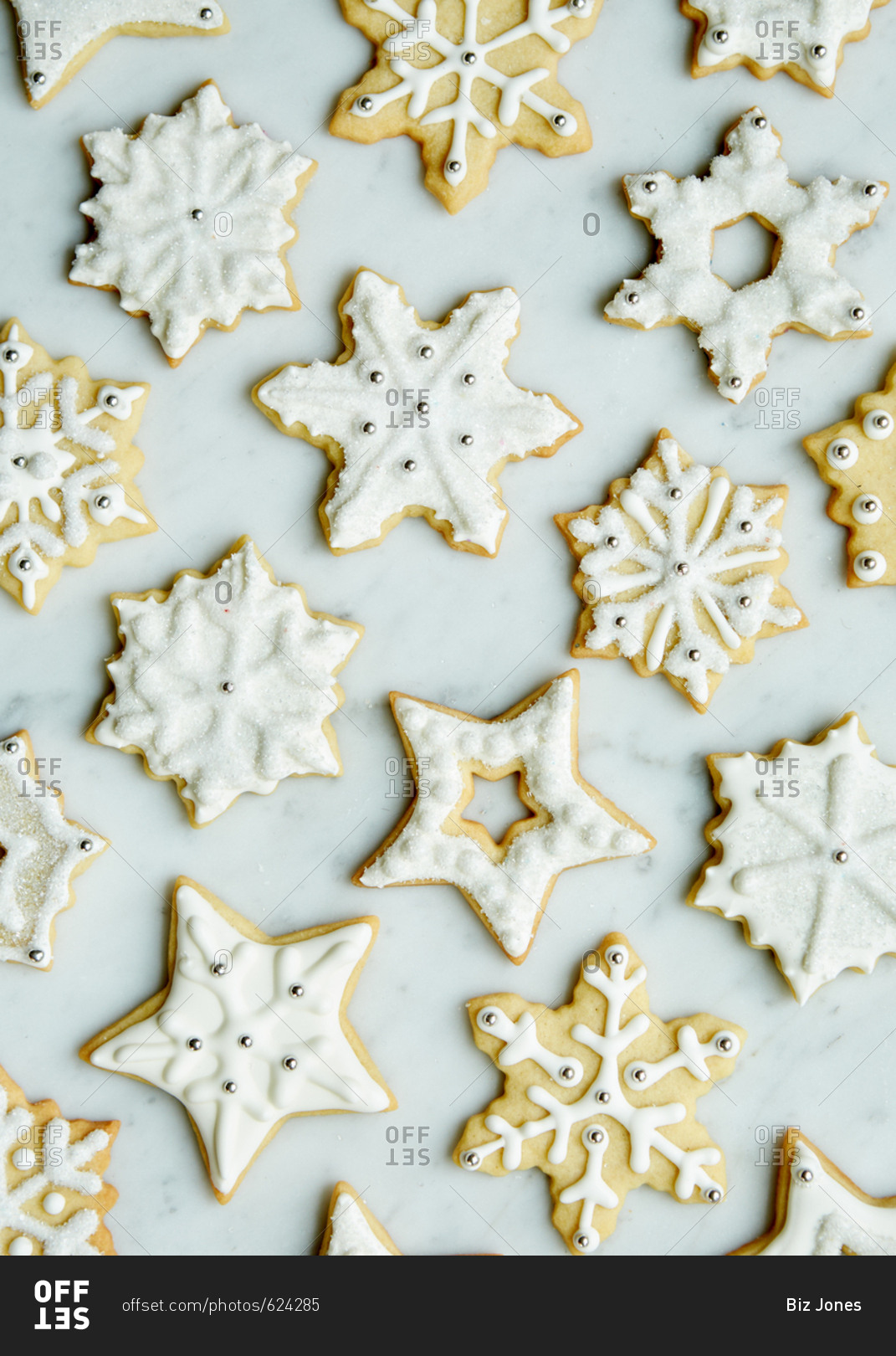 Fancy winter sugar cookies decorated with royal icing and sprinkles on a white marble surface