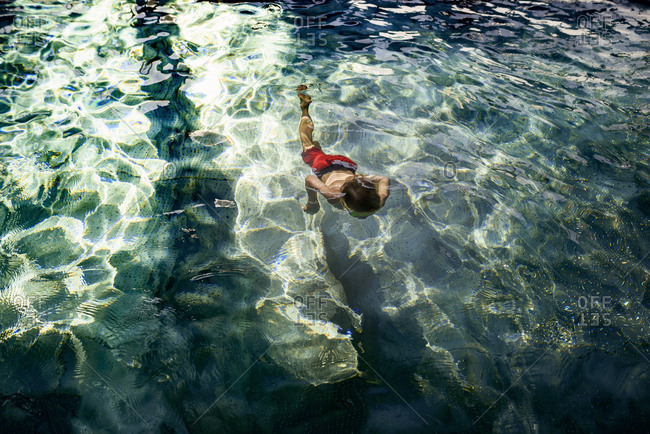 Young boy swimming in pool