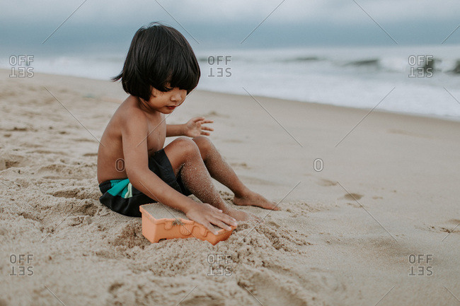 Boy playing in the sand on the beach