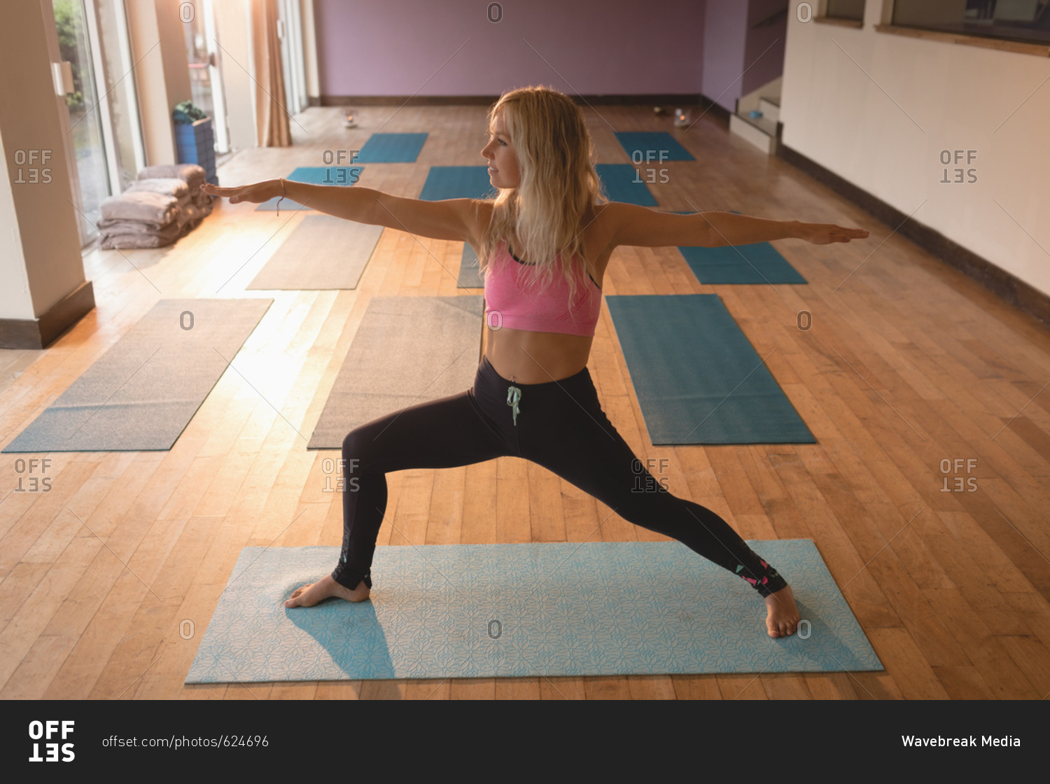 Fit woman doing yoga exercise in yoga class