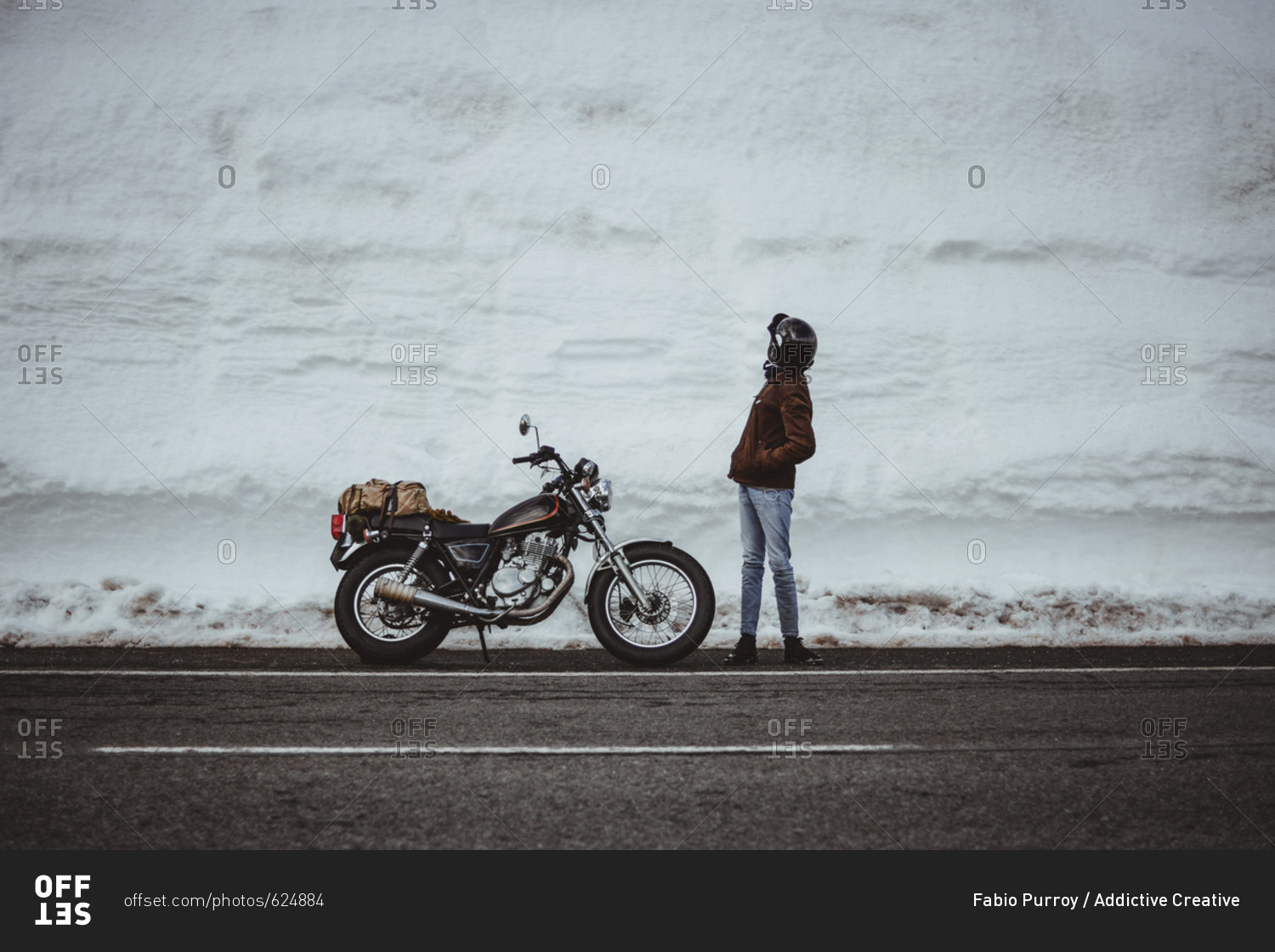Man with motorcycle in snowy road