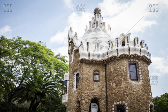 Barcelona, Spain - May 27, 2015: The Park Guell is an Antoni Gaudi-designed public park system composed of gardens and architectonic elements located on Monte Carmelo in Barcelona. Here the pavilion and the tower at the entrance