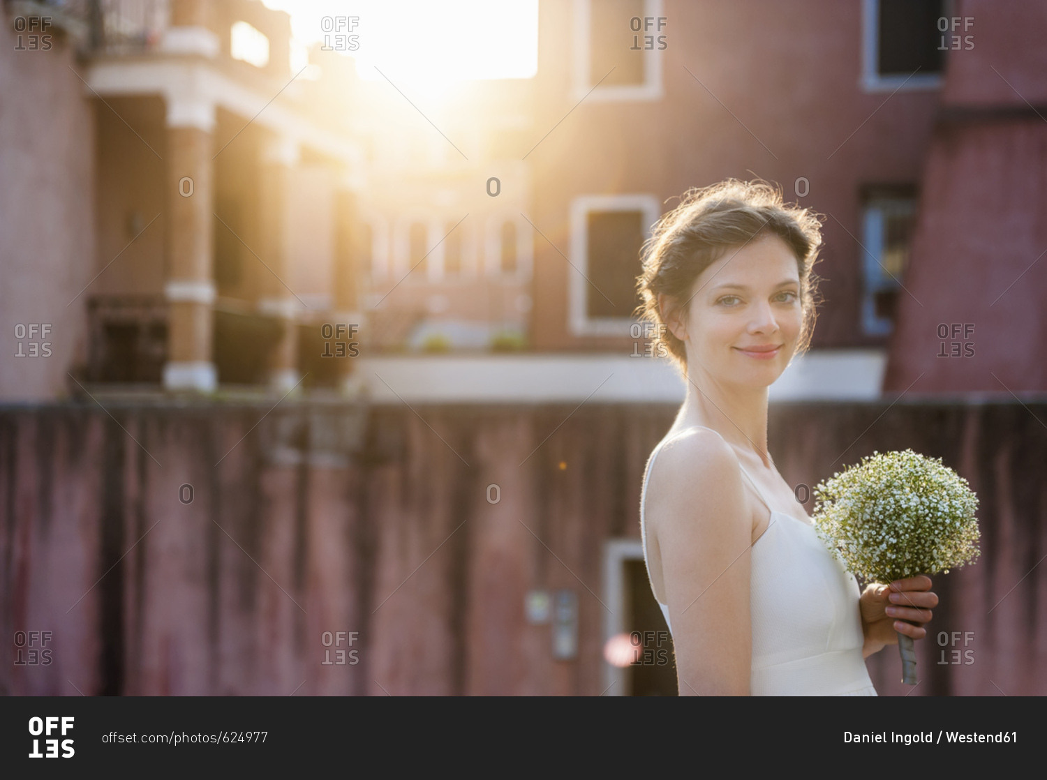 Italy- Venice- portrait of smiling bride with bridal bouquet at sunrise