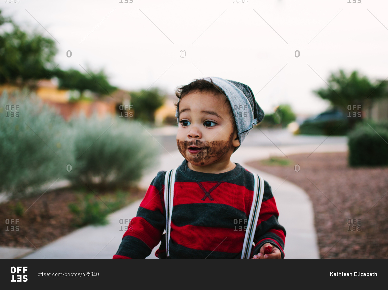 Toddler boy dressed for Halloween with beard and suspenders