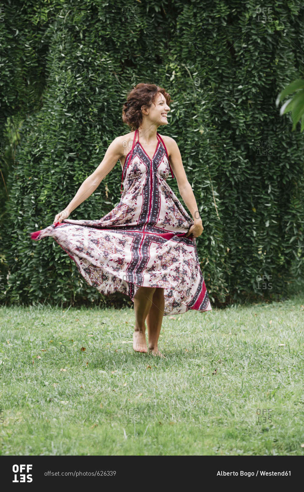 Happy woman in a park wearing summer dress