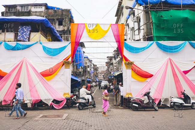 Mumbai, India - July 2, 2017: Brightly colored tents and fabric decorate the entrance to a busy street market