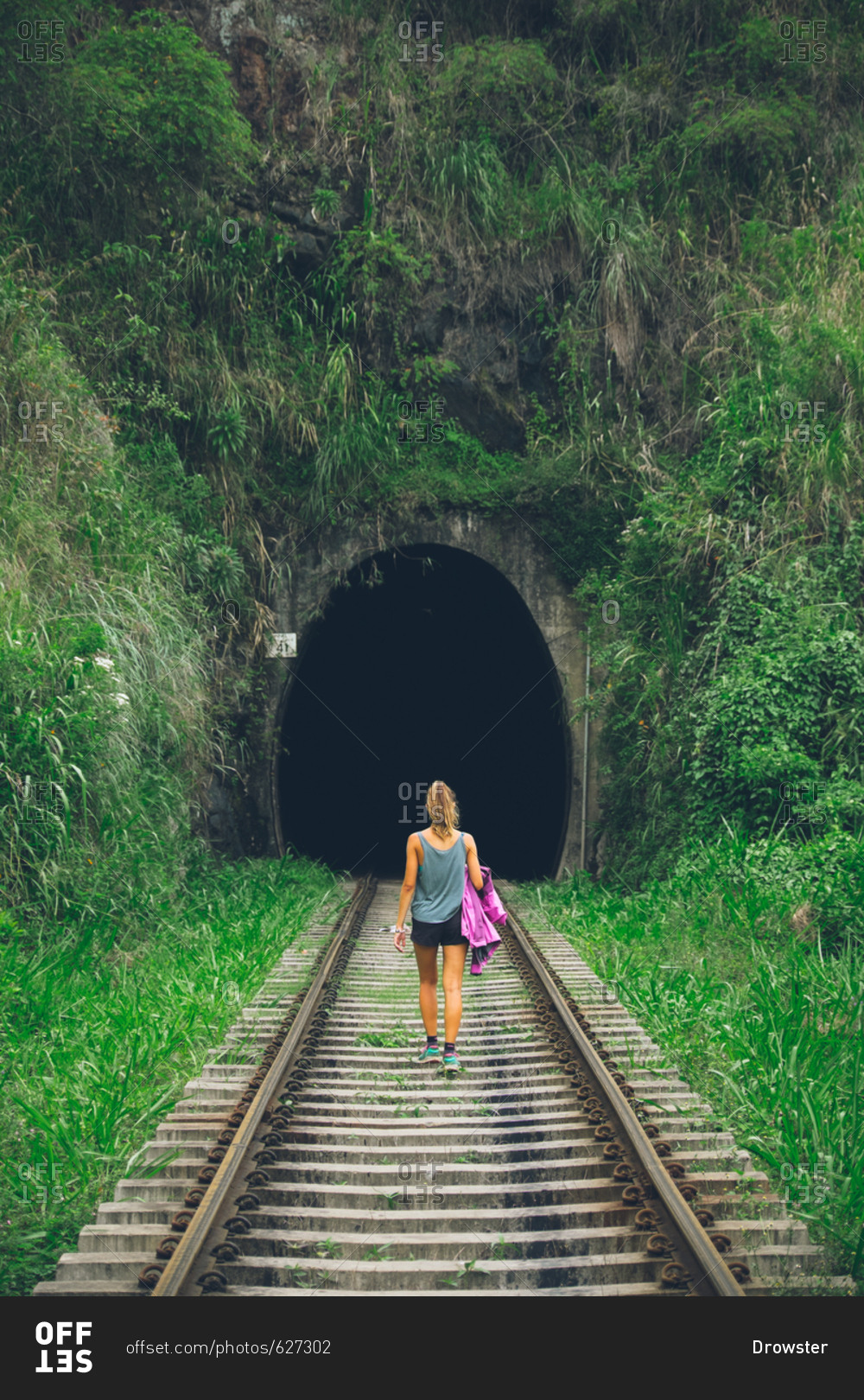 Woman hiking on train tracks into a tunnel Ella, Sri Lanka stock photo ...