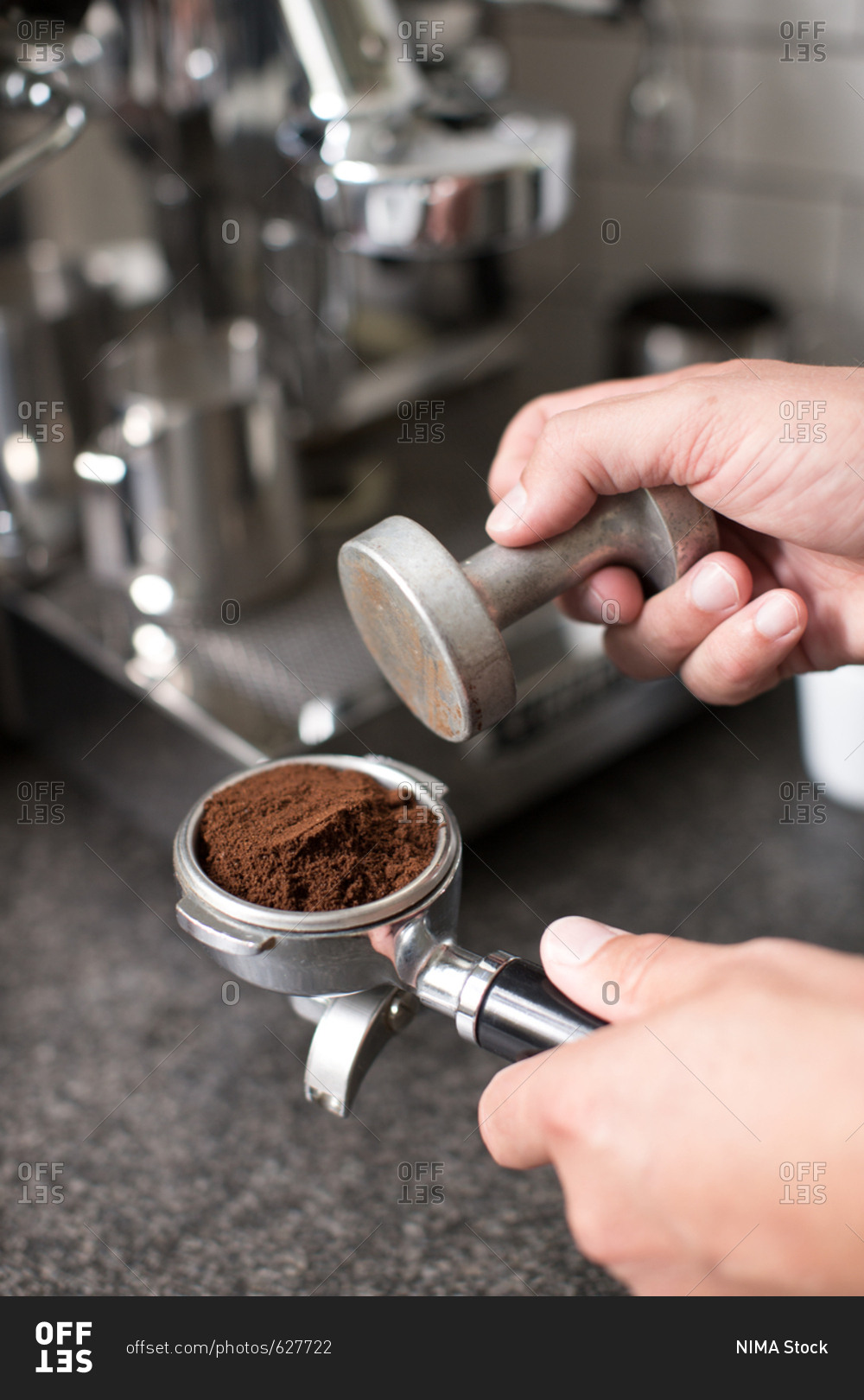 Barista tamping espresso coffee