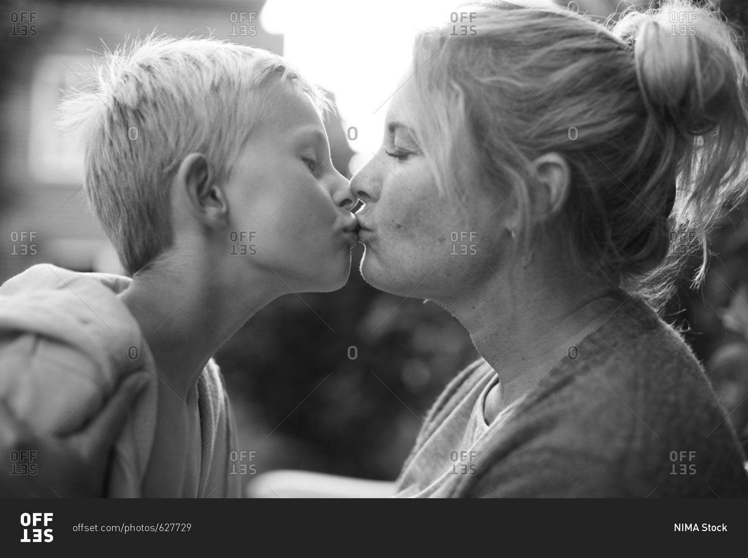Mother and son kissing outdoors