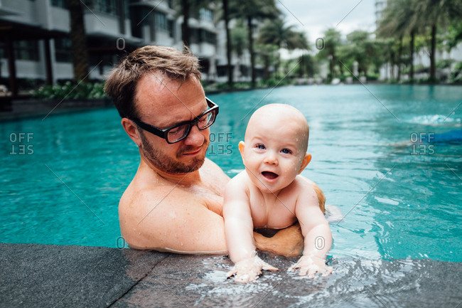 Father holding baby in a pool
