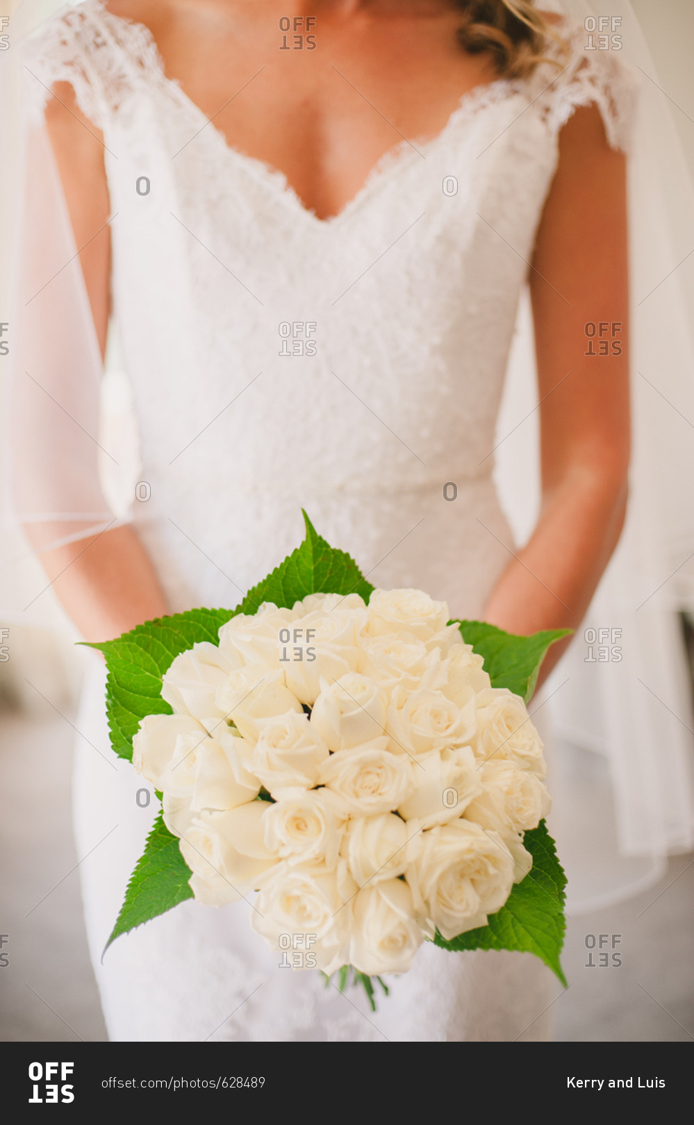Bride holding bouquet of white roses