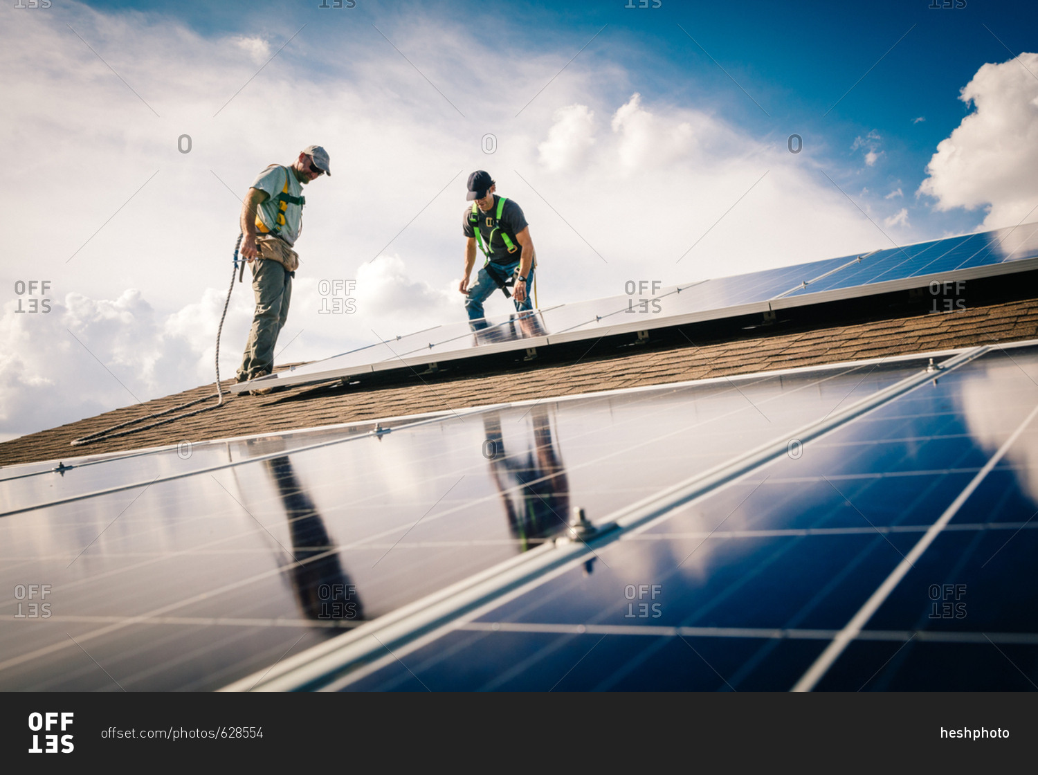 Construction workers on a roof installing solar panels
