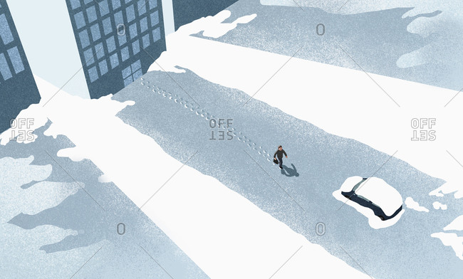 High angle view of man walking on snow covered road in city