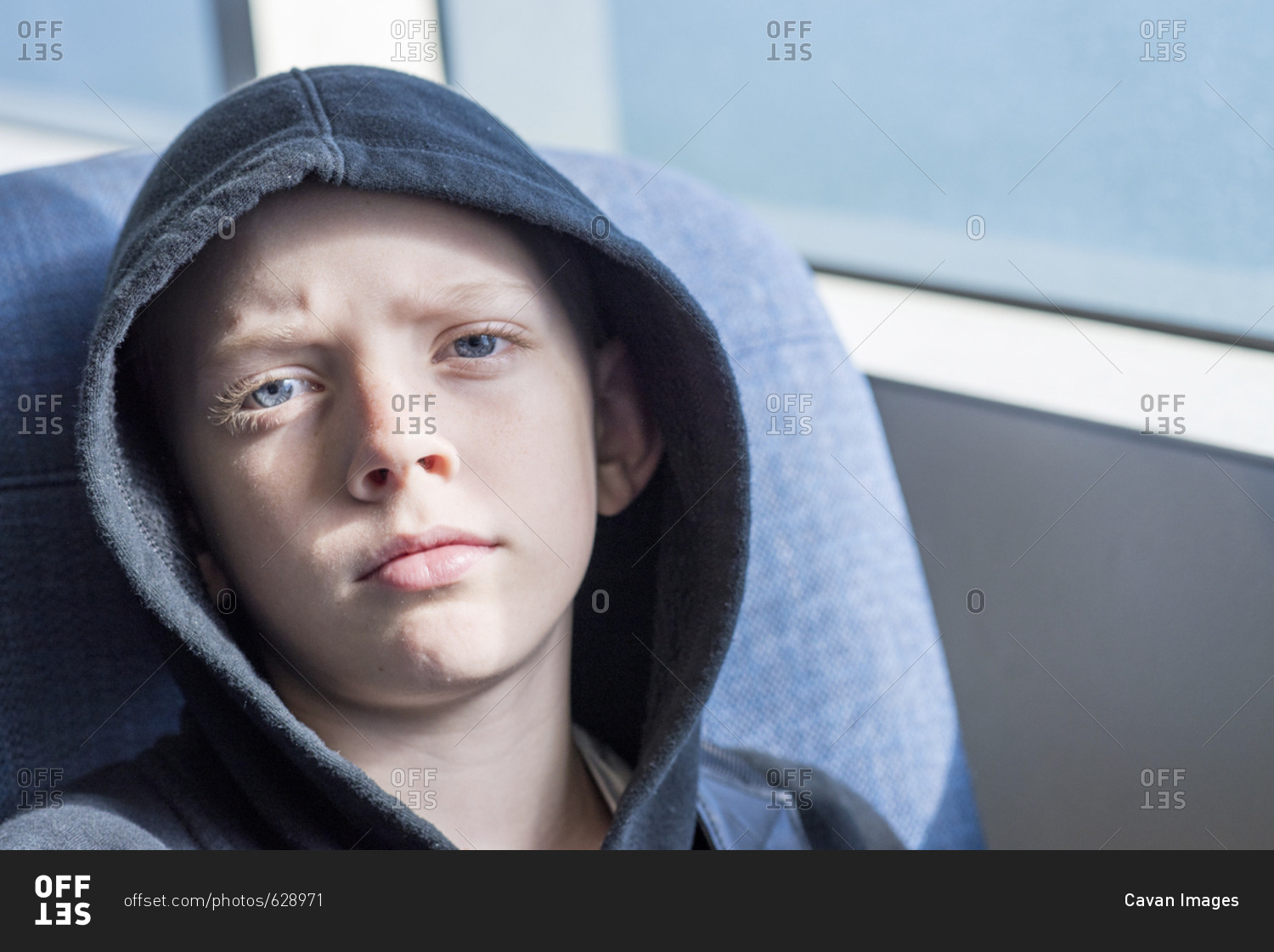 Close-up portrait of confident boy wearing hooded shirt in bus