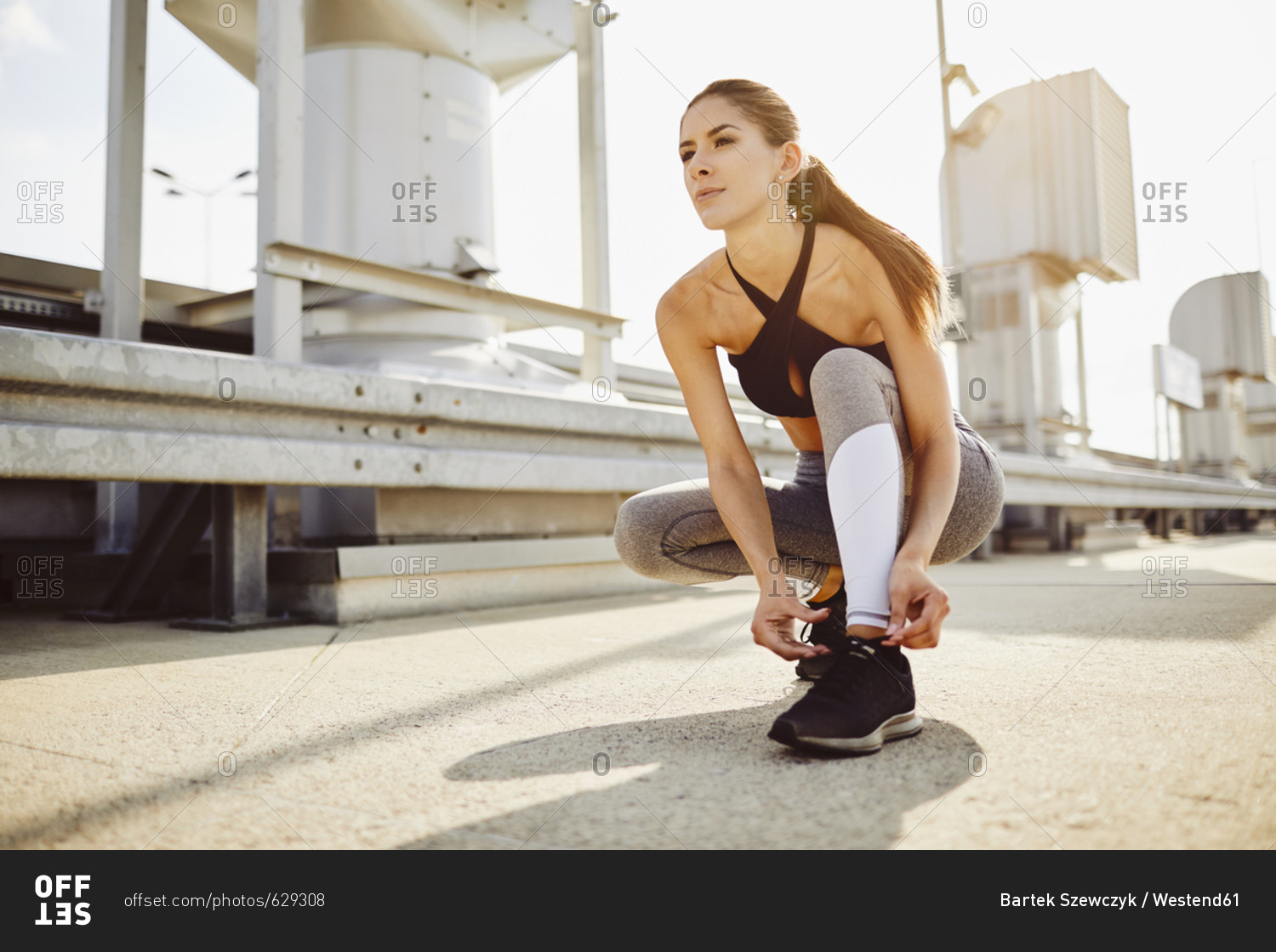 Young woman tying her shoes before workout