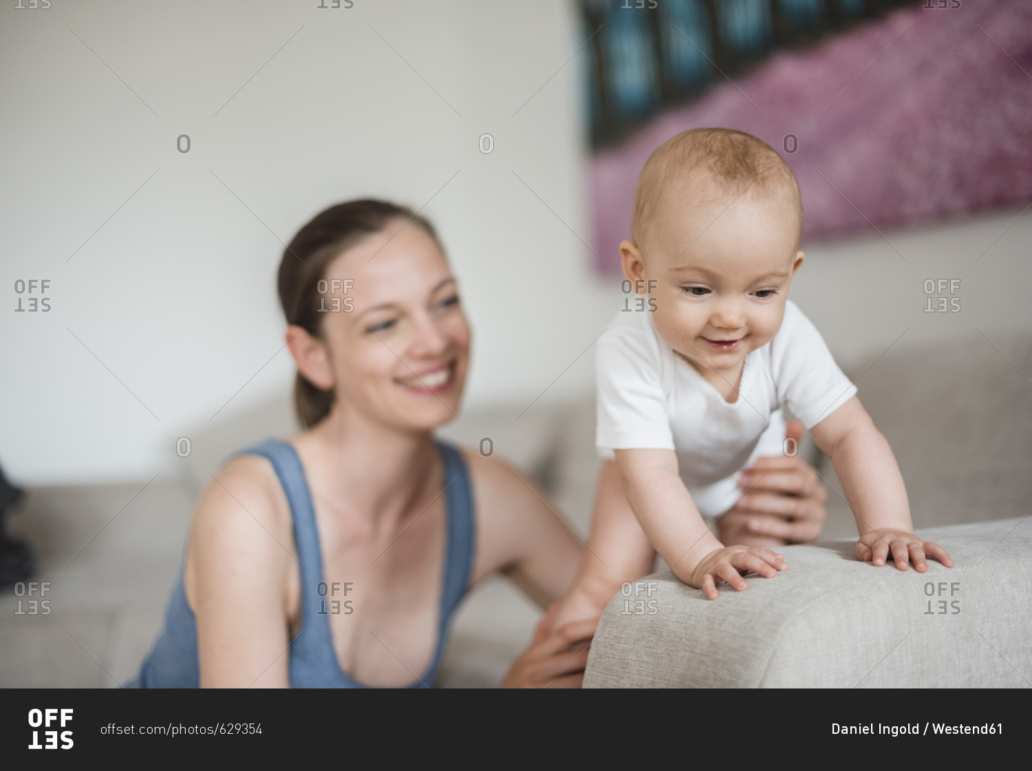Happy baby girl with mother on couch