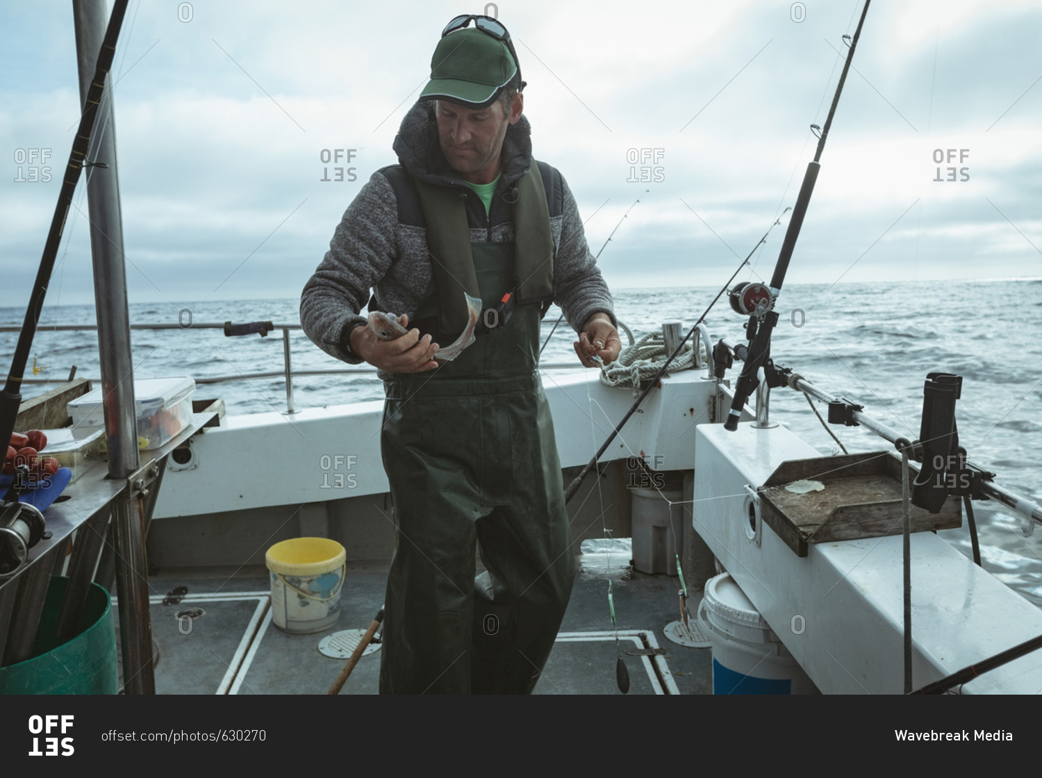 Fisherman holding fish on boat