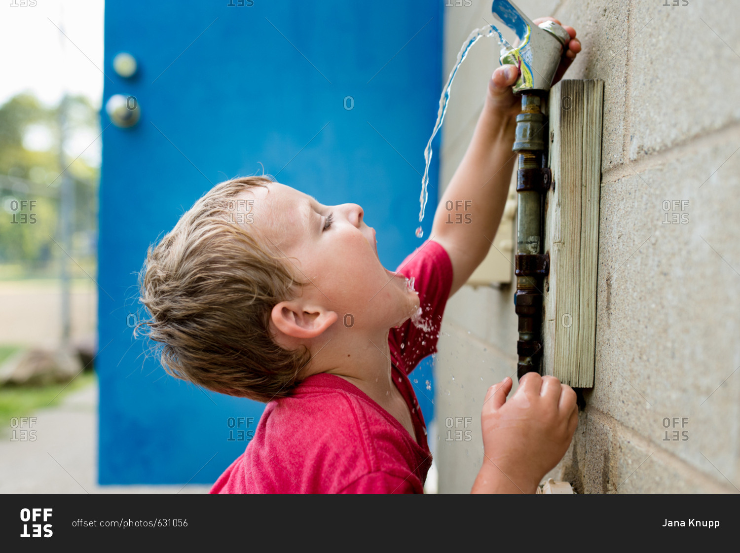 Boy drinking out of drinking fountain