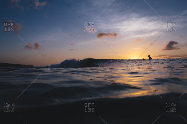Uluwatu, Bali, Indonesia - November 28, 2017: Silhouette of surfer waiting for wave at sunset