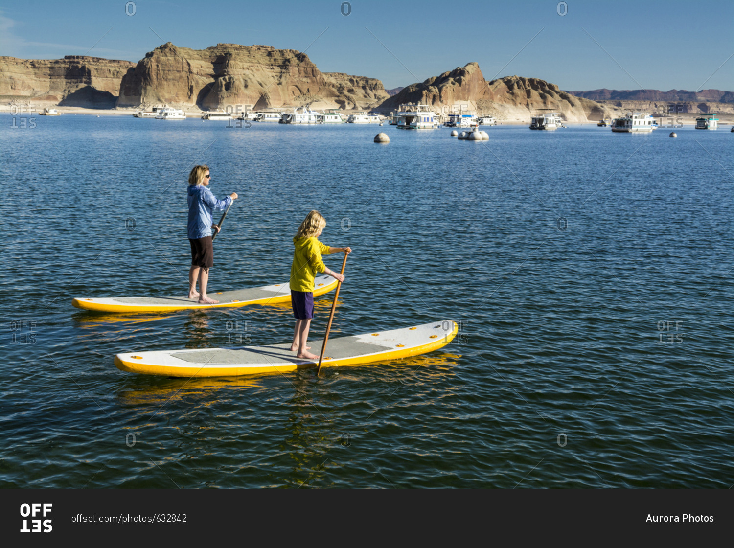 A mother and daughter paddleboarding on Lake Powell, Wahweap Marina, Glen Caynon National Recreation Area, Page,  Arizona.