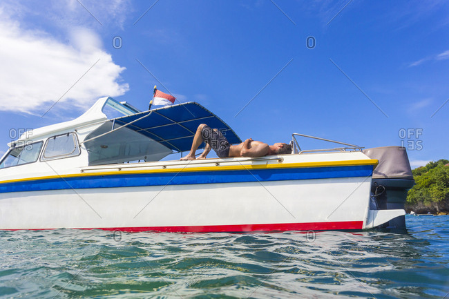 Shirtless Man Relaxing On The Boat