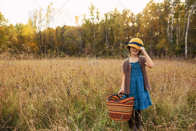Young girl in a field with a woven basket