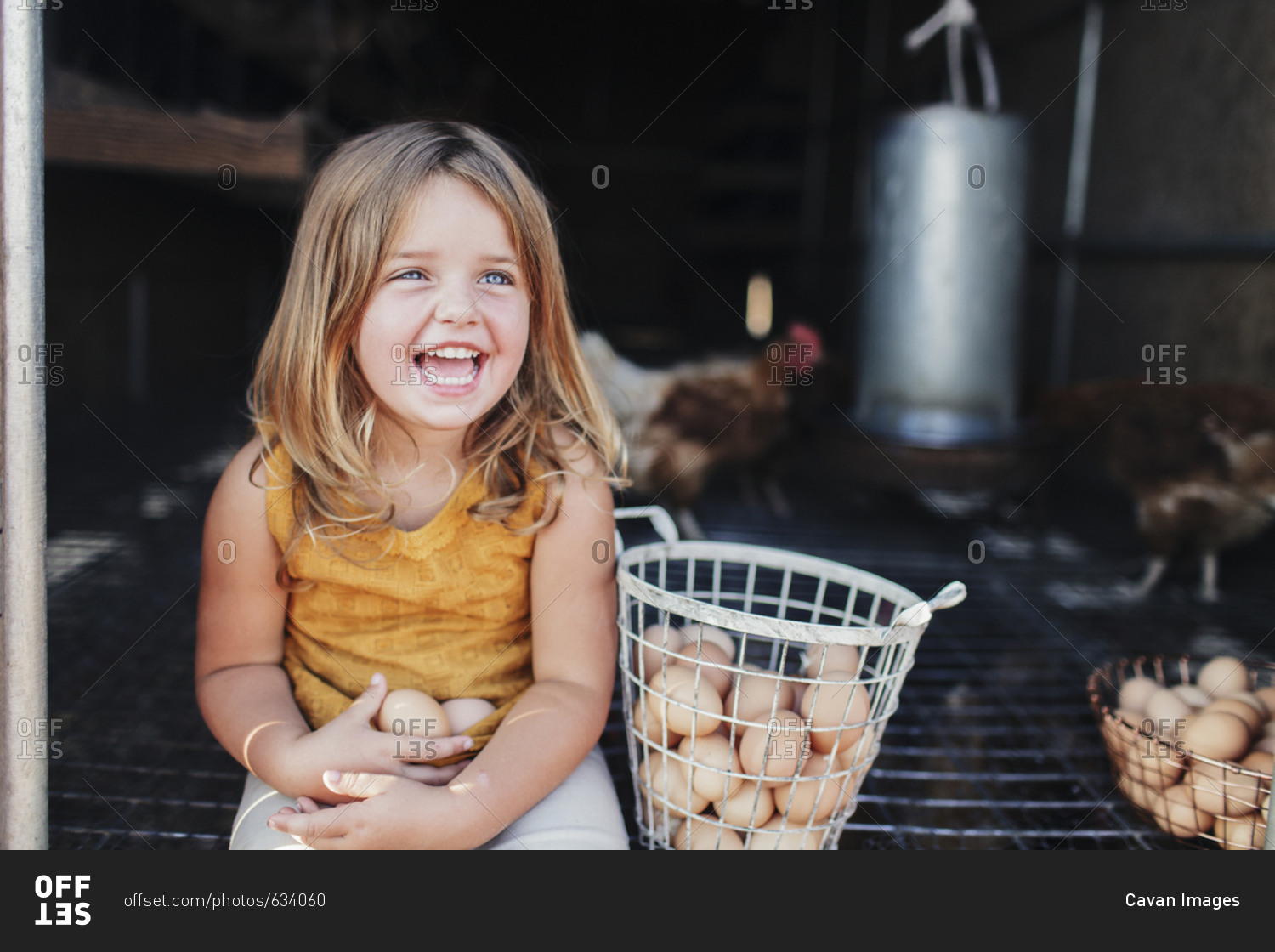 Cheerful girl sitting in animal pen