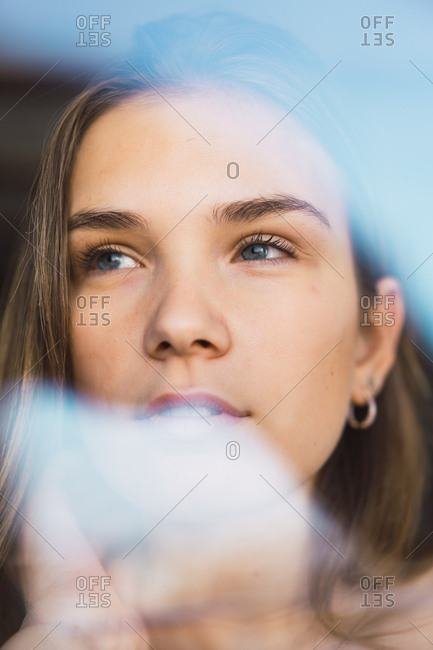 Beautiful young woman through glass