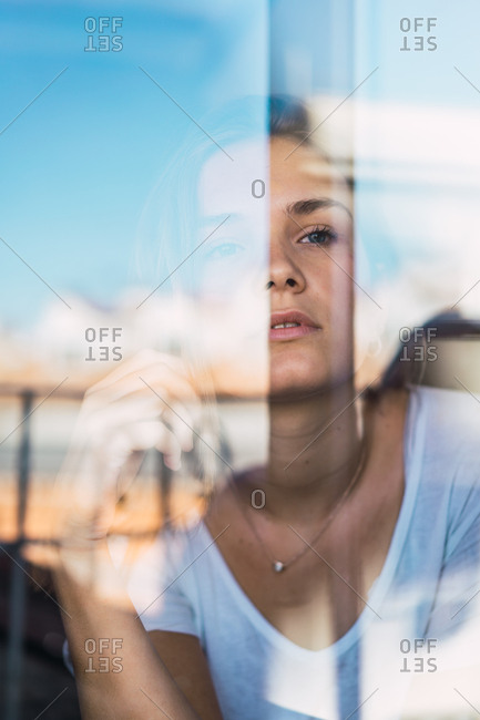 Beautiful young woman through glass