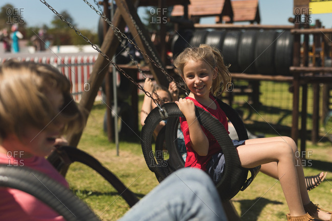 Children swinging on tire swing on a sunny day