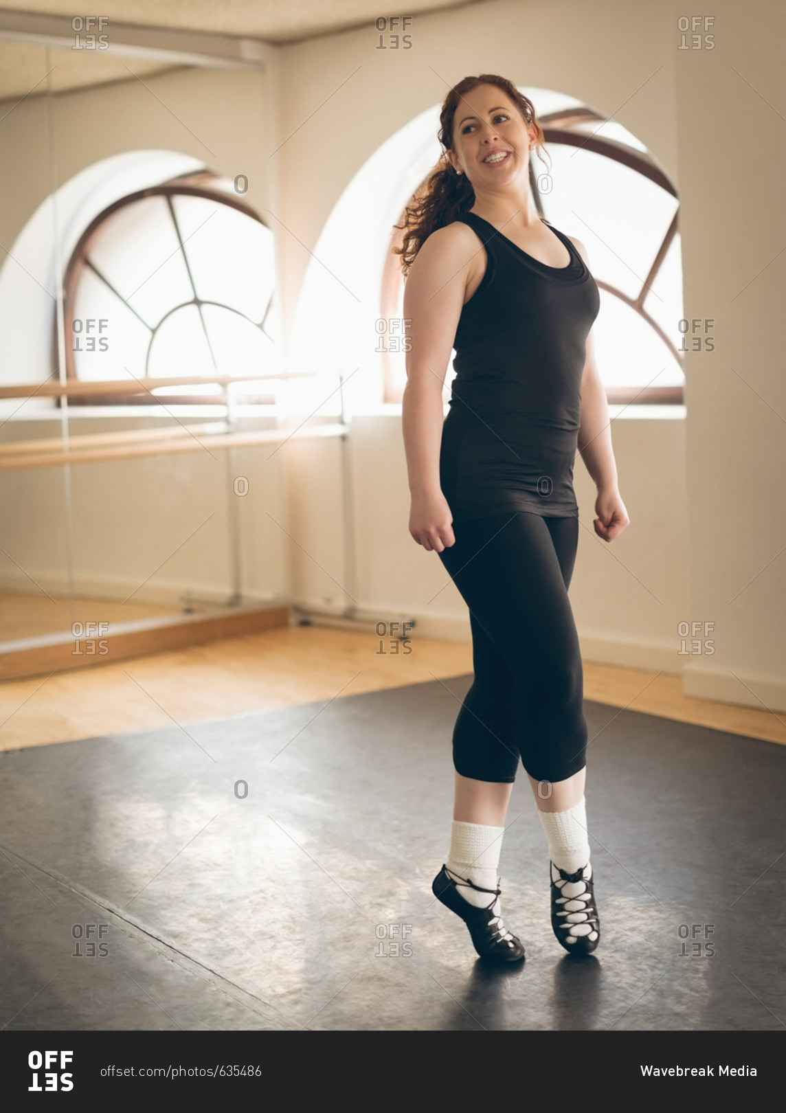 Irish dancer in sportswear performing dance steps in the studio