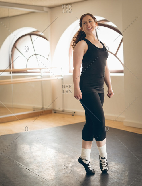 Irish dancer in sportswear performing dance steps in the studio