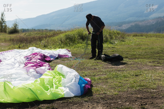 Paraglider preparing the parachute for paragliding on a sunny day