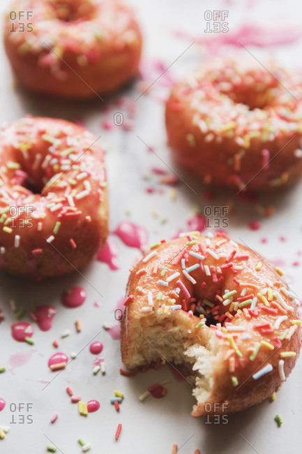 Decorated rustic donuts with a bite taken from one