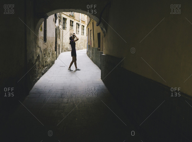 Teenage girl composing photo with digital camera, Gothic Quarter, Barcelona, Spain.