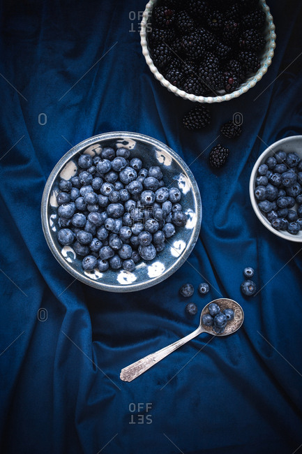 Blueberries and blackberries on a blue background