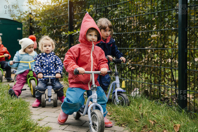Children using scooters in garden of a kindergarten