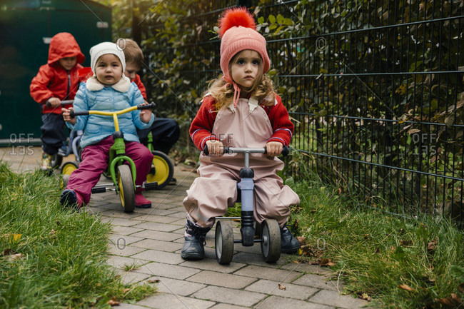 Children using scooters in garden of a kindergarten