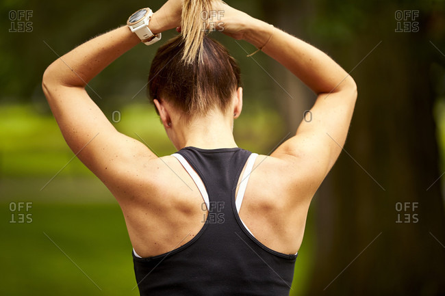 Back view of woman's brown hair tied in a ponytail stock photo - OFFSET