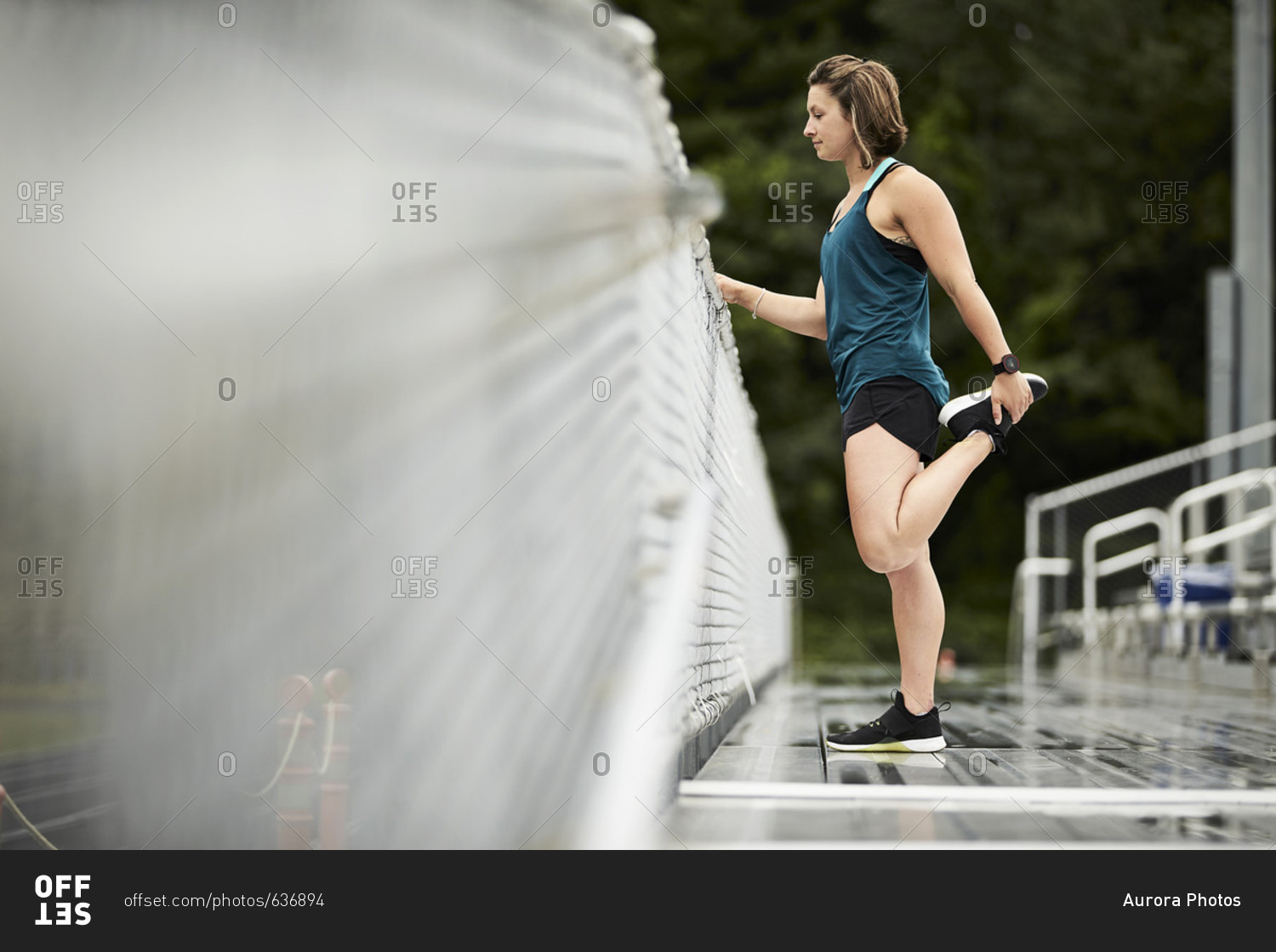 Side view of female athlete doing quadriceps muscle stretches, Lincoln, Massachusetts, USA